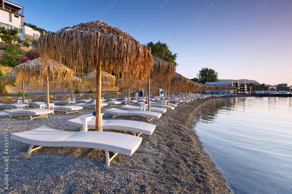 希腊克里特岛米拉贝洛湾带遮阳伞的日光浴床