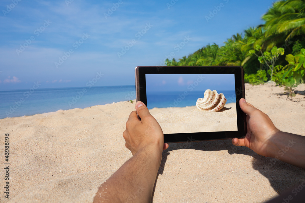 海滩上手持平板电脑