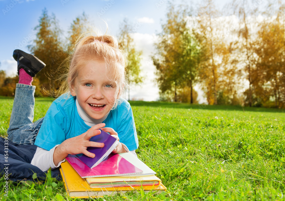 公园里带书的可爱小女孩