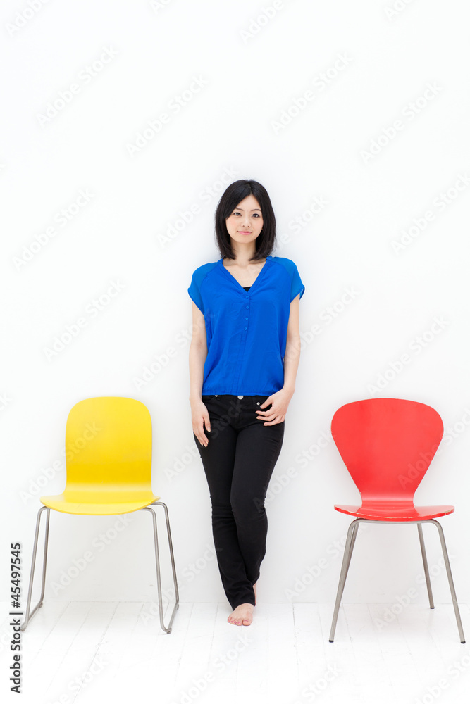 一个年轻的亚洲女人，带着五颜六色的椅子