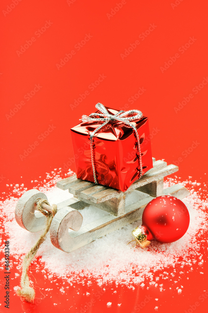 Christmas sleigh with gift on red background