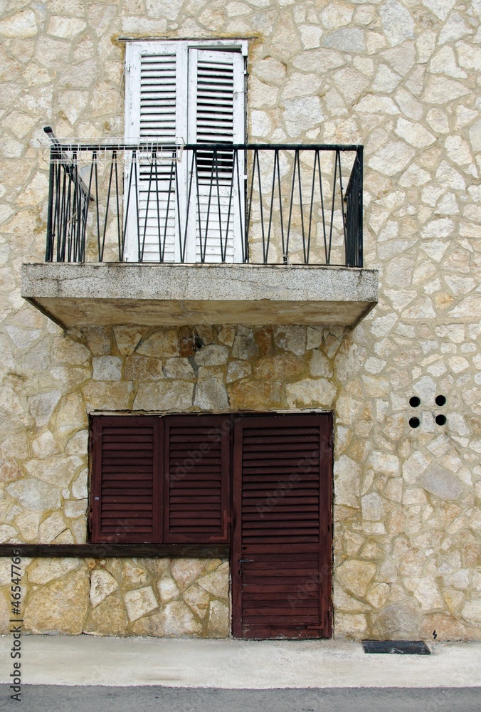 Old wooden door and shutters in stone house
