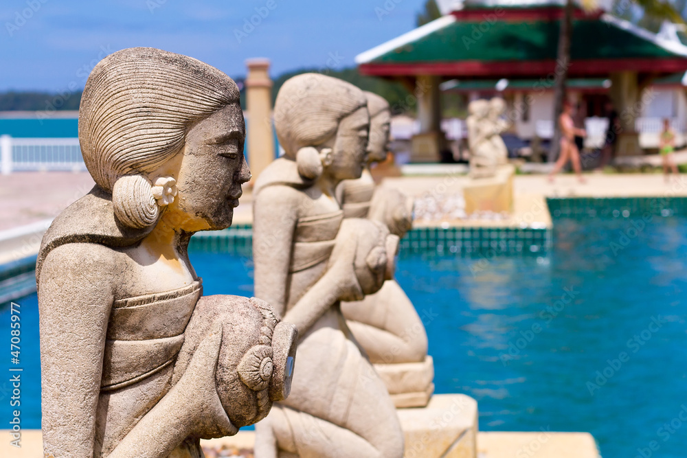 Fountain statues at the tropical swimming pool in Thailand