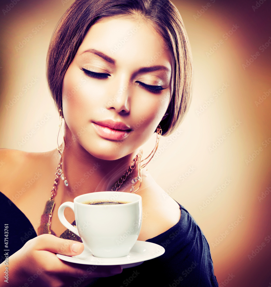 美丽的女孩在喝茶或咖啡。Sepia Toned