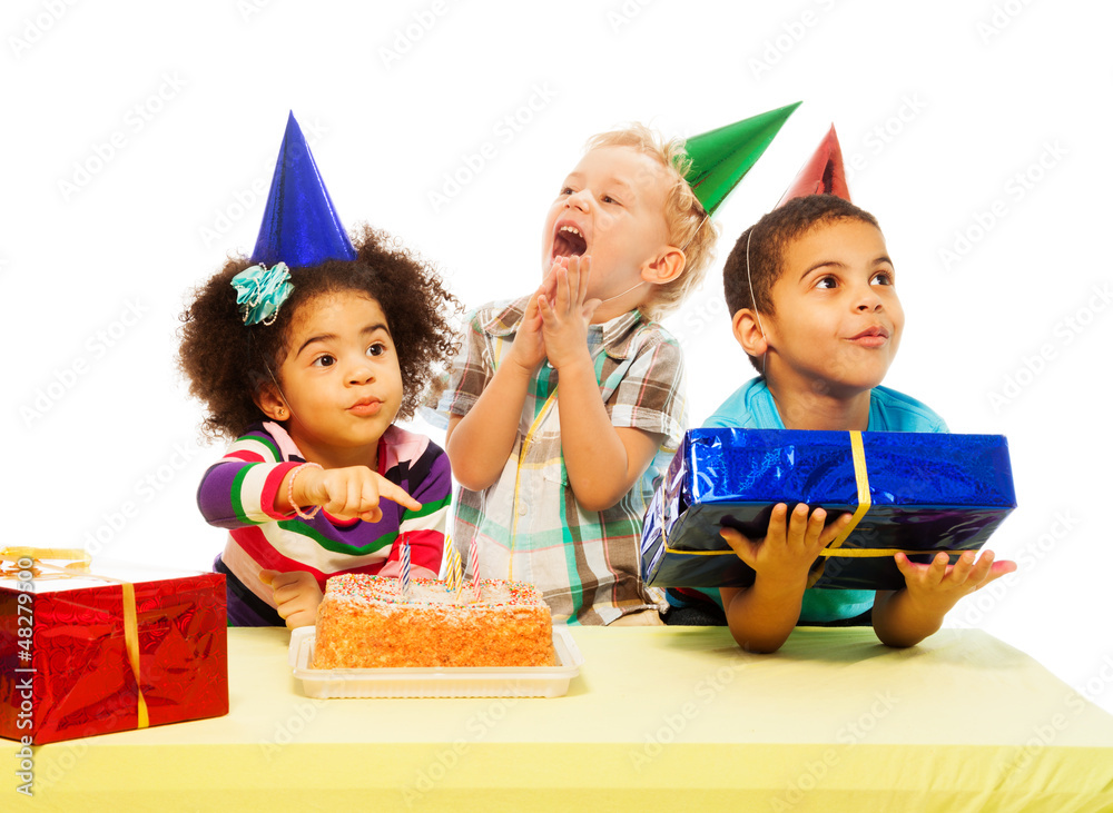 Three kids with birthday cake and peresents