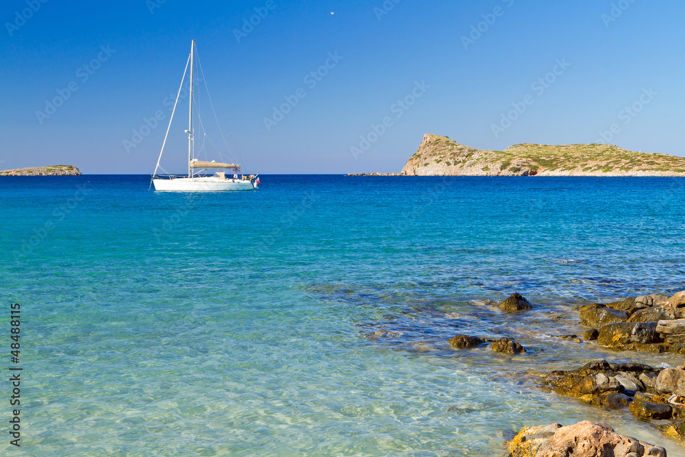 White yacht on the idyllic beach lagoon of Crete, Greece