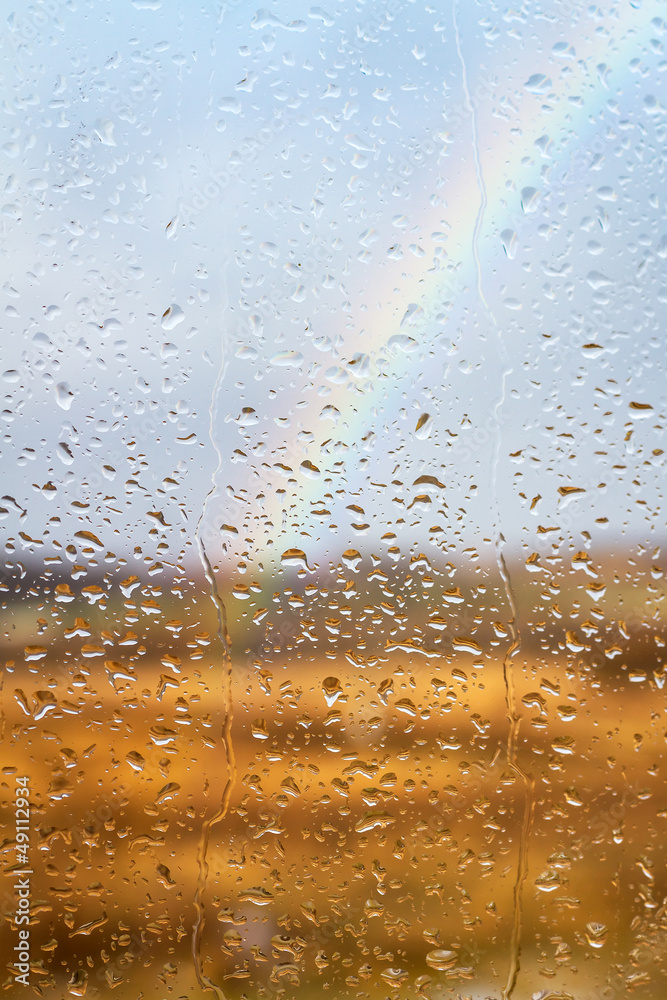 彩虹穿过雨水滴落的窗户