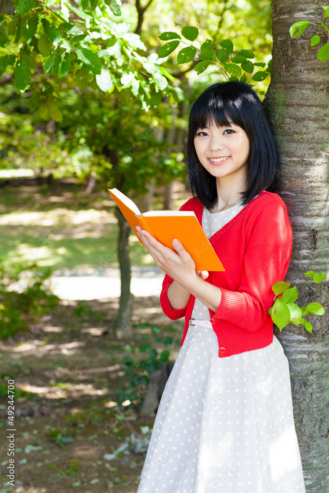一个活跃的亚洲女人在公园里看书