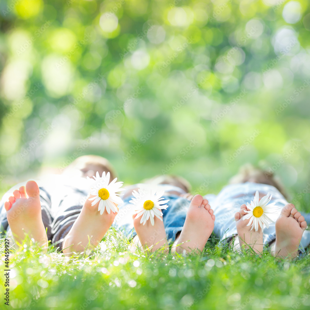 Family with flowers lying on green grass. Healthy lifestyle conc