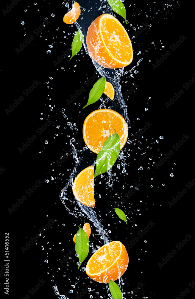 橙色在水中飞溅，在黑色背景上隔离