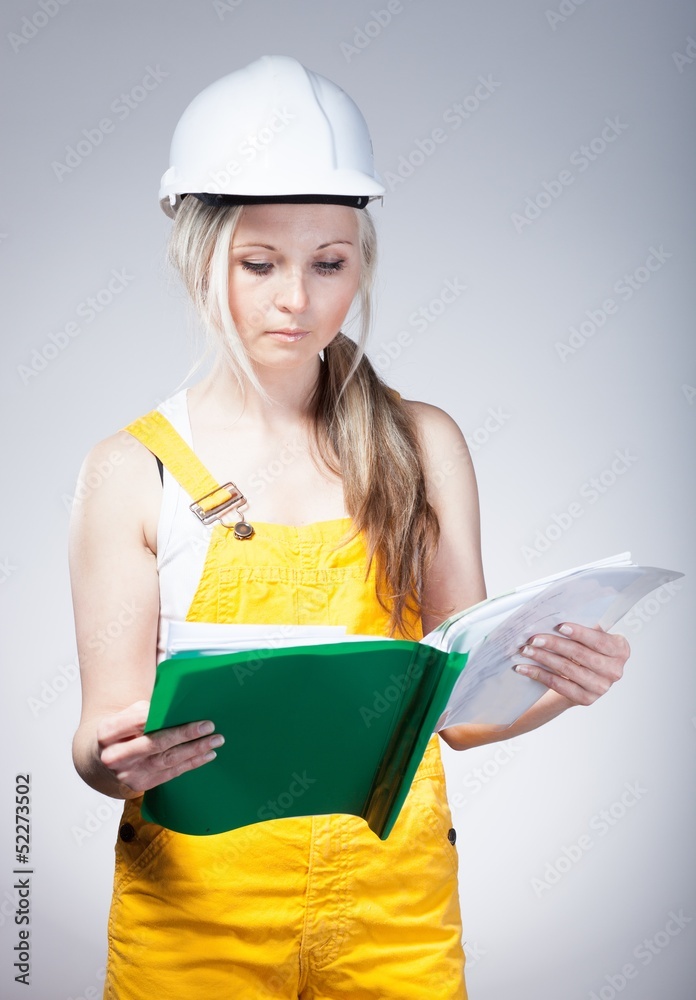年轻建筑师、女建筑工人阅读蓝图