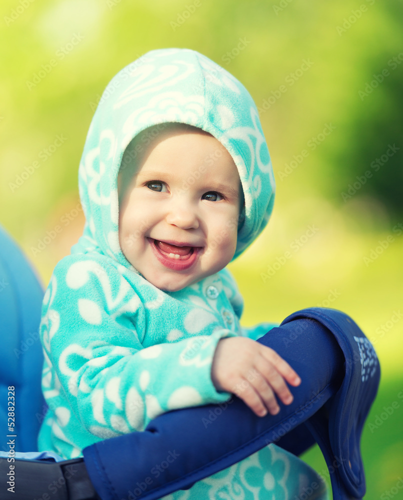 快乐的婴儿在婴儿车里戴着蓝色帽子微笑着走进来