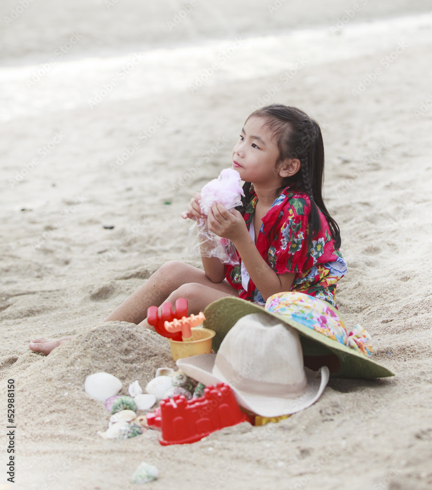 女孩在海滩上玩她的玩具