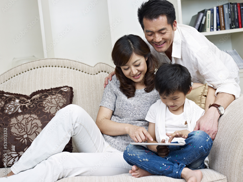 asian family using tablet computer at home
