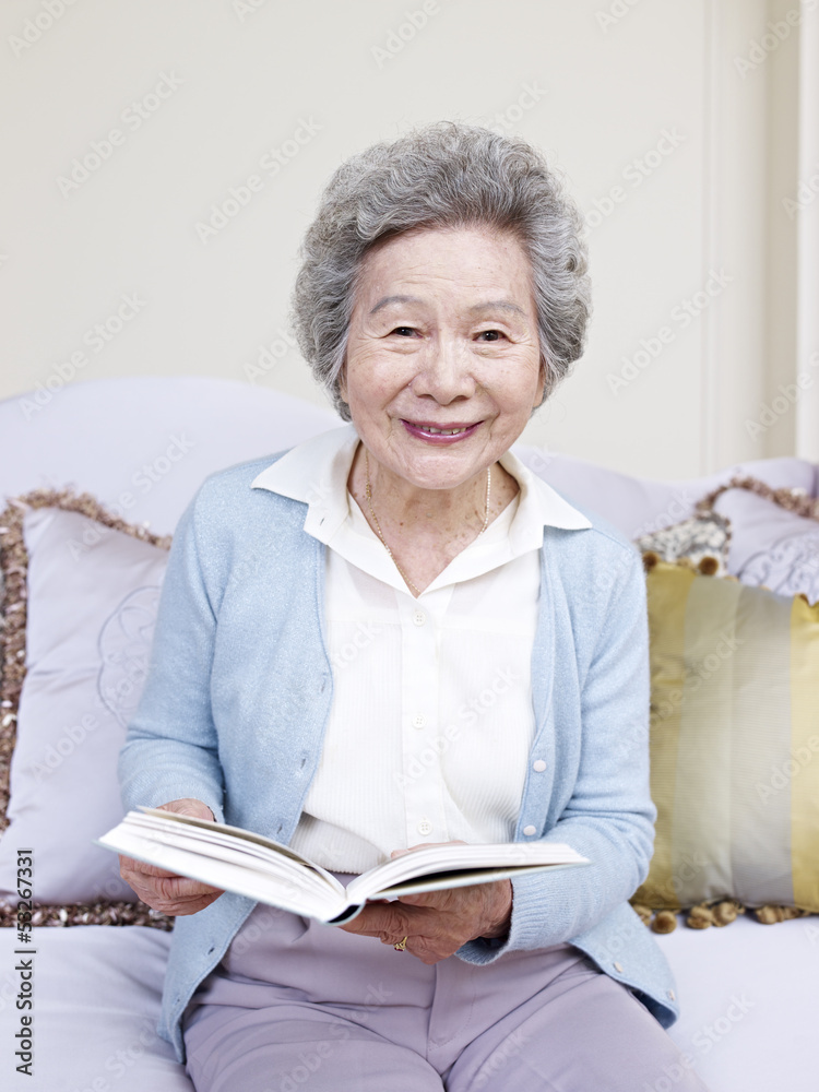 senior woman holding a book and smiling