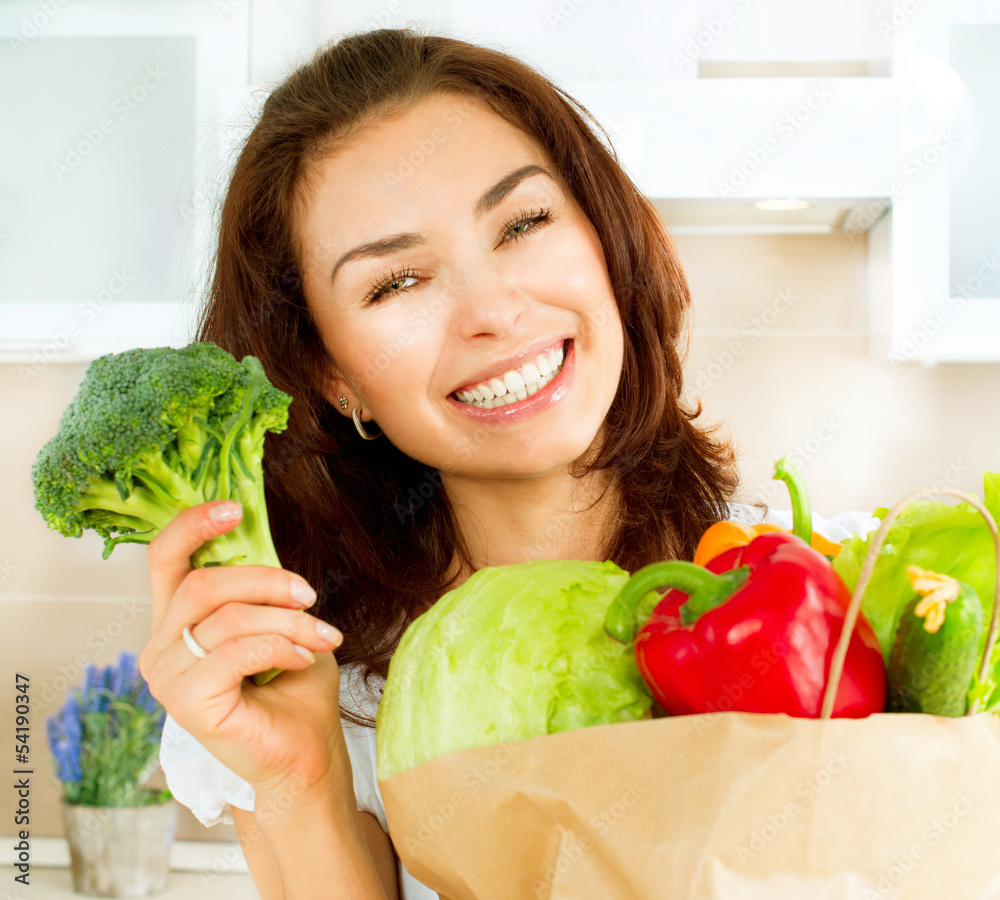 购物袋里有蔬菜的快乐年轻女人。饮食理念