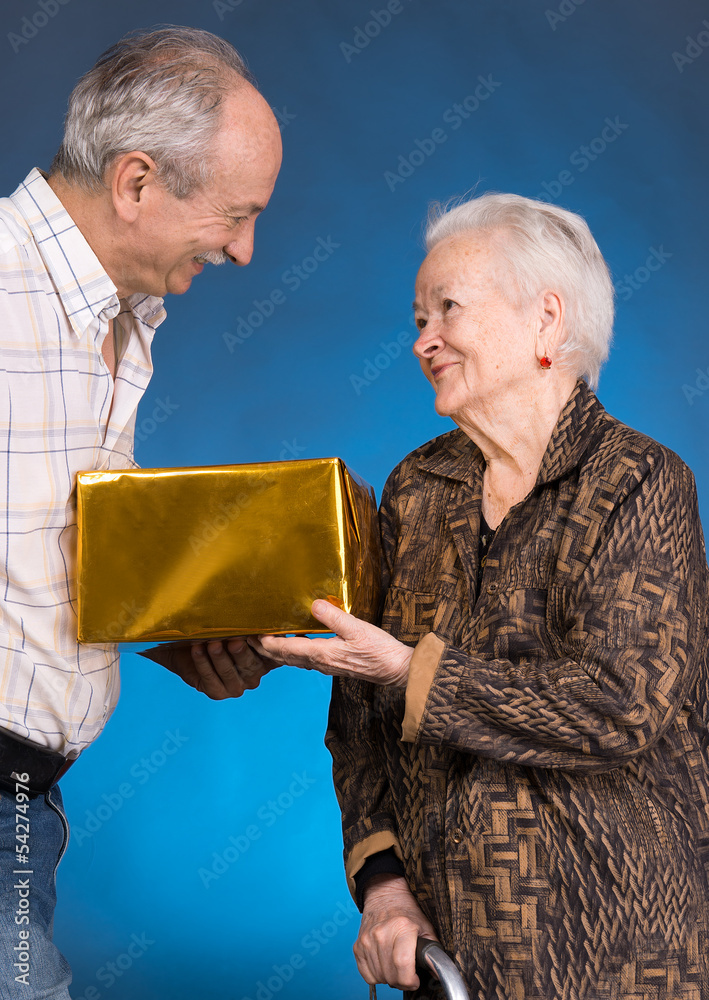 一个带礼物盒的成年儿子和年迈的母亲