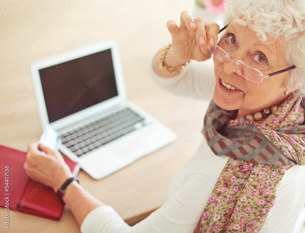 老妇人在笔记本电脑前看着你