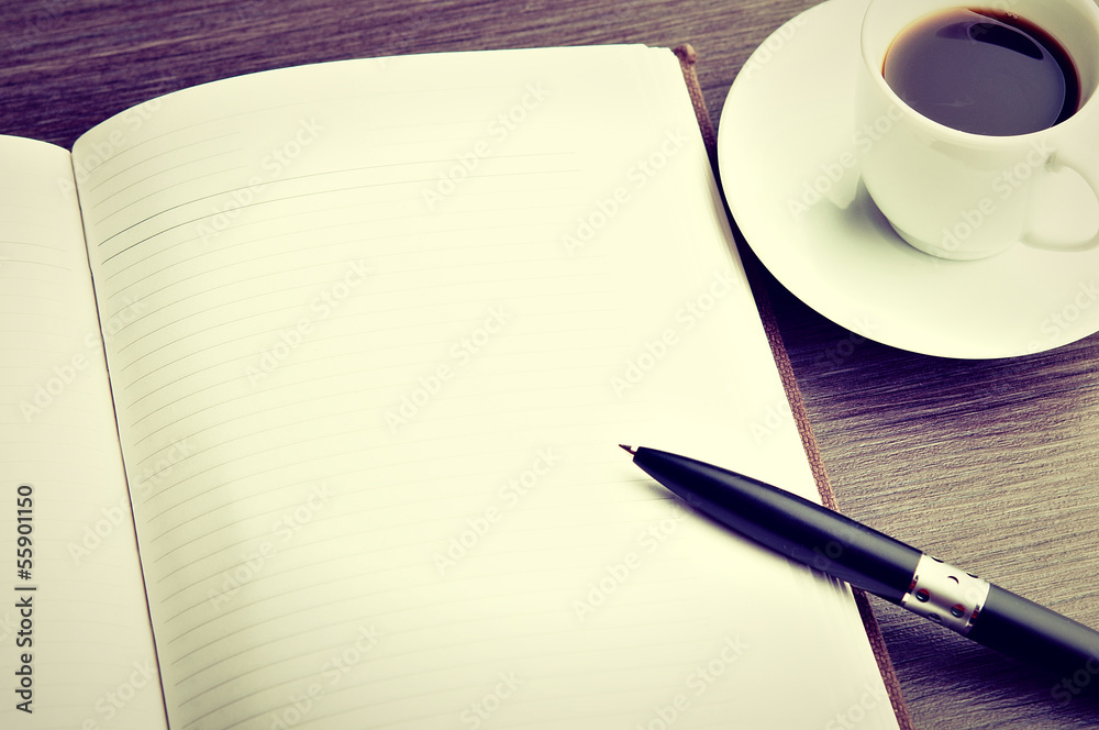 打开桌子上的空白白色笔记本、钢笔和咖啡