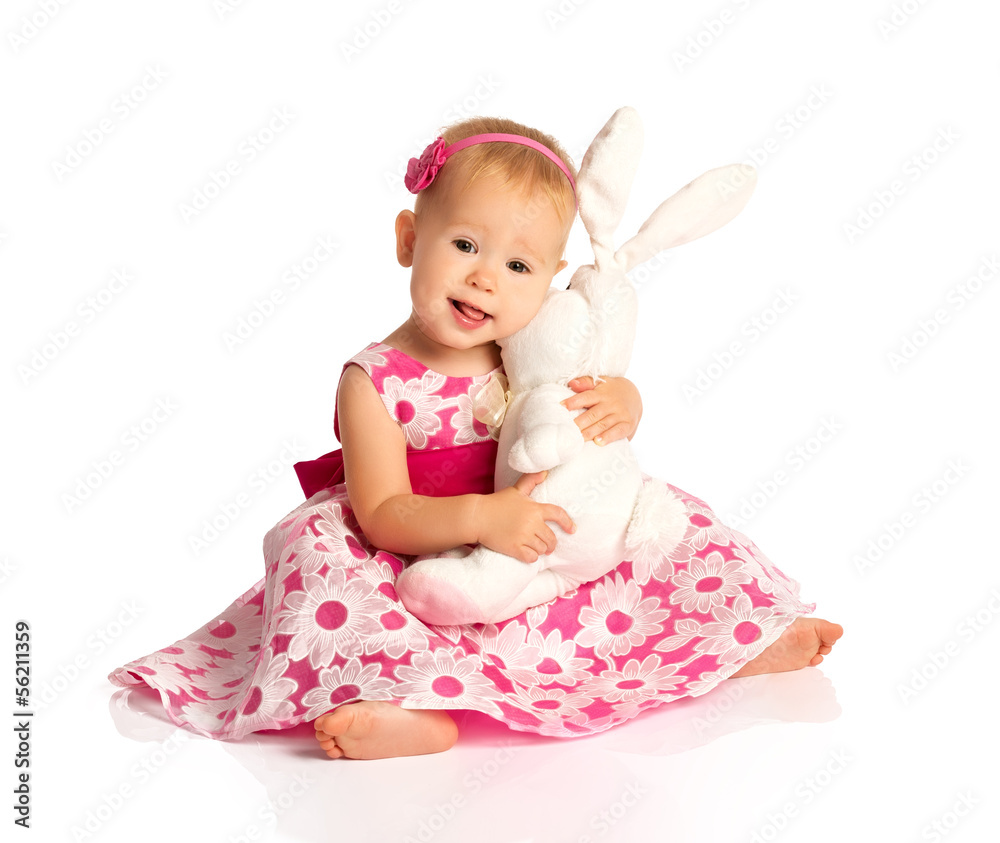小女婴抱着一只被隔离在白色的玩具兔子