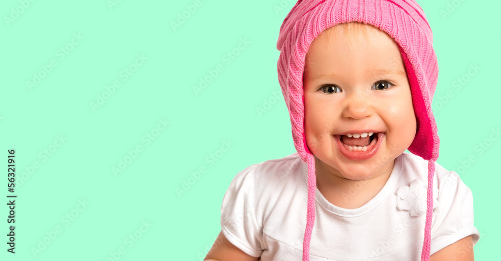 戴着粉色冬季针织帽的有趣快乐的女婴大笑