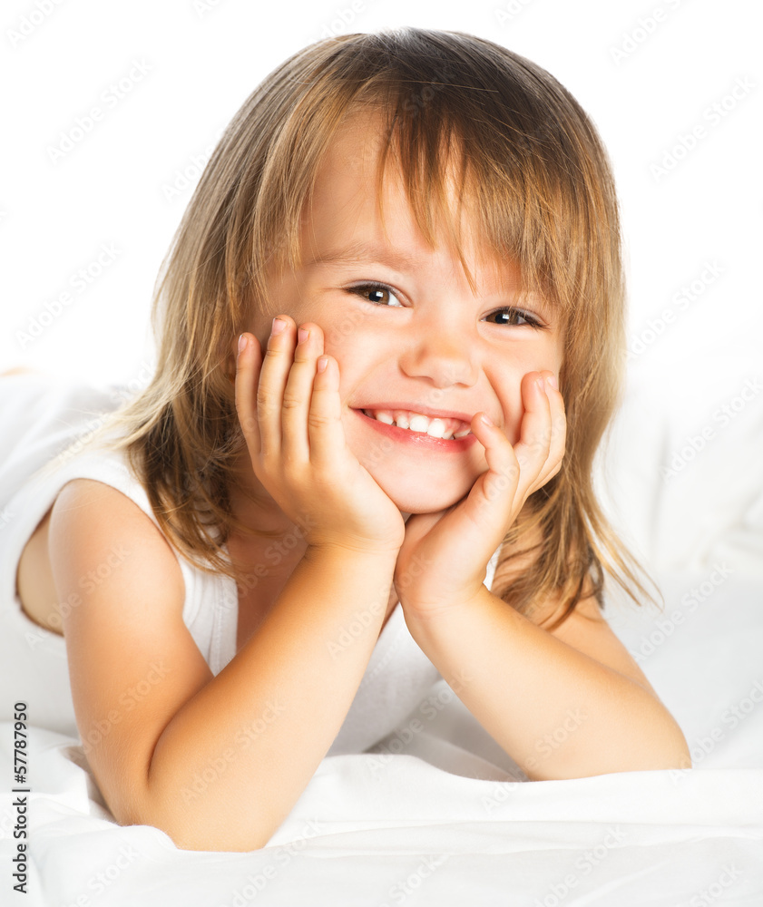 隔离在床上的快乐微笑的快乐小女孩