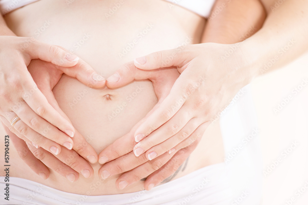 夫妻怀胎。怀孕的肚子有手指心脏符号