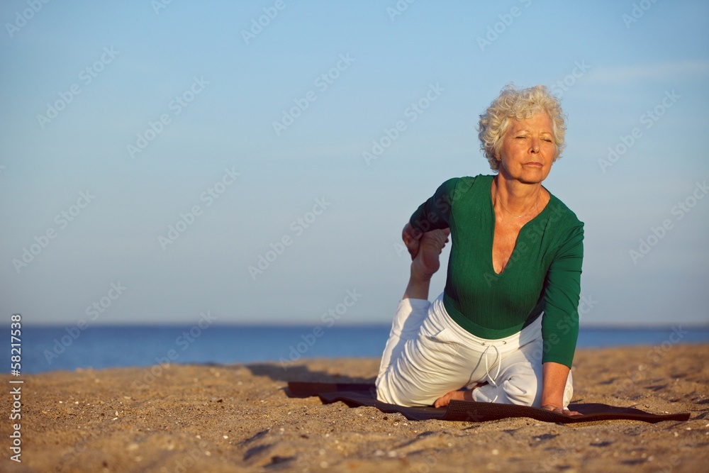在海边做瑜伽的资深女性