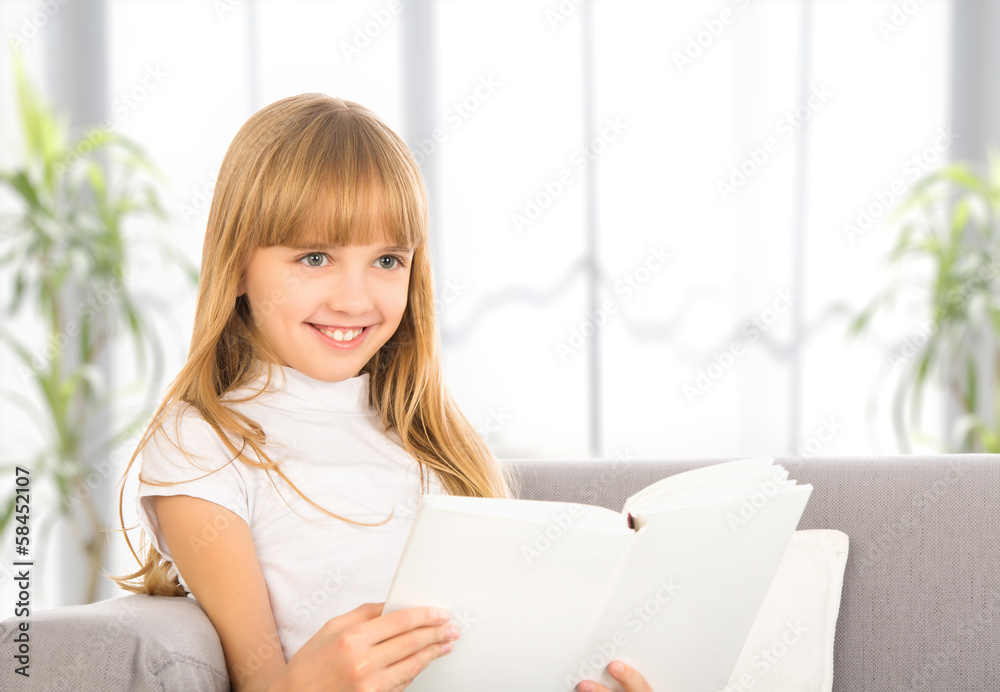 快乐的小女孩坐在沙发上看书