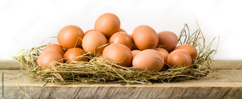 干草窝里的鸡蛋。白色隔离。有机食品