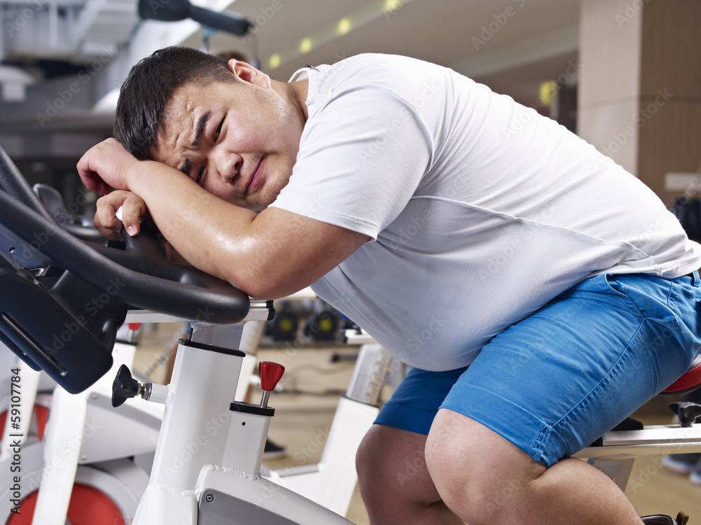 超重男子在健身房筋疲力尽