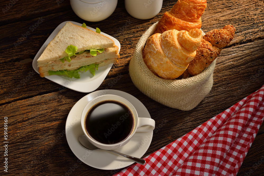 咖啡杯配三明治和羊角面包。
