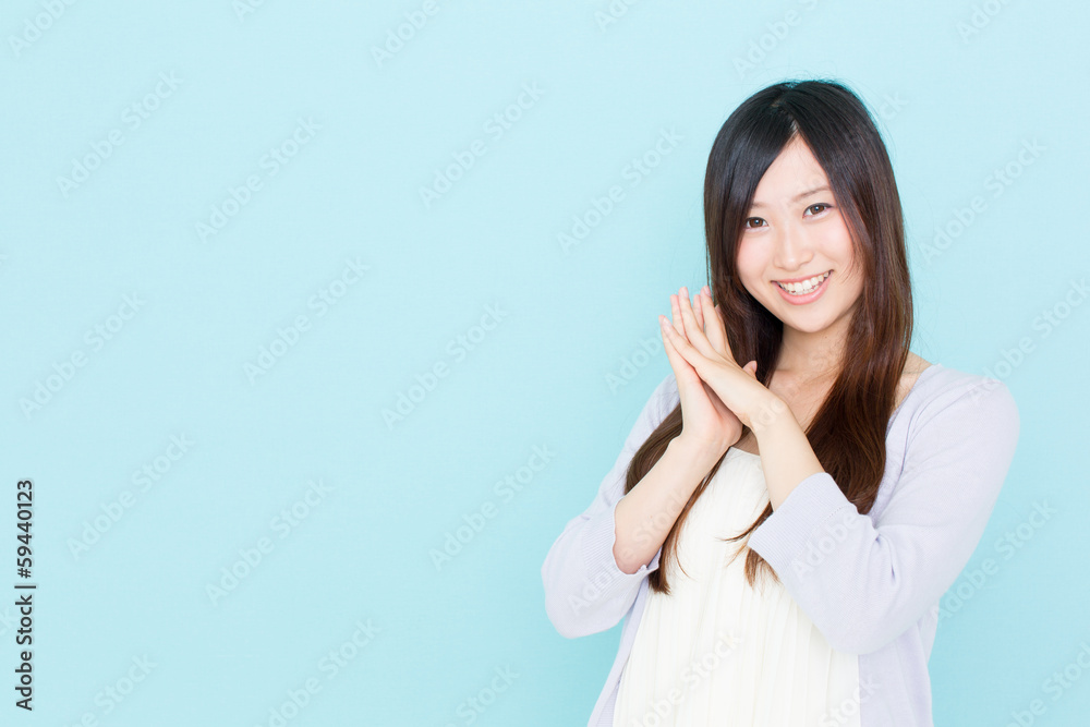年轻的亚洲女性在蓝色背景下欢呼