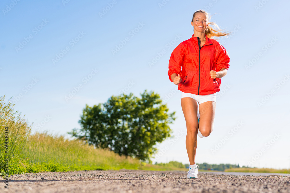 年轻的运动女性在路上奔跑