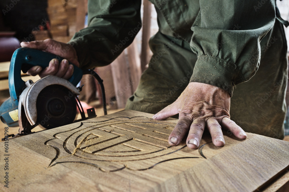 man cutting wood by machine