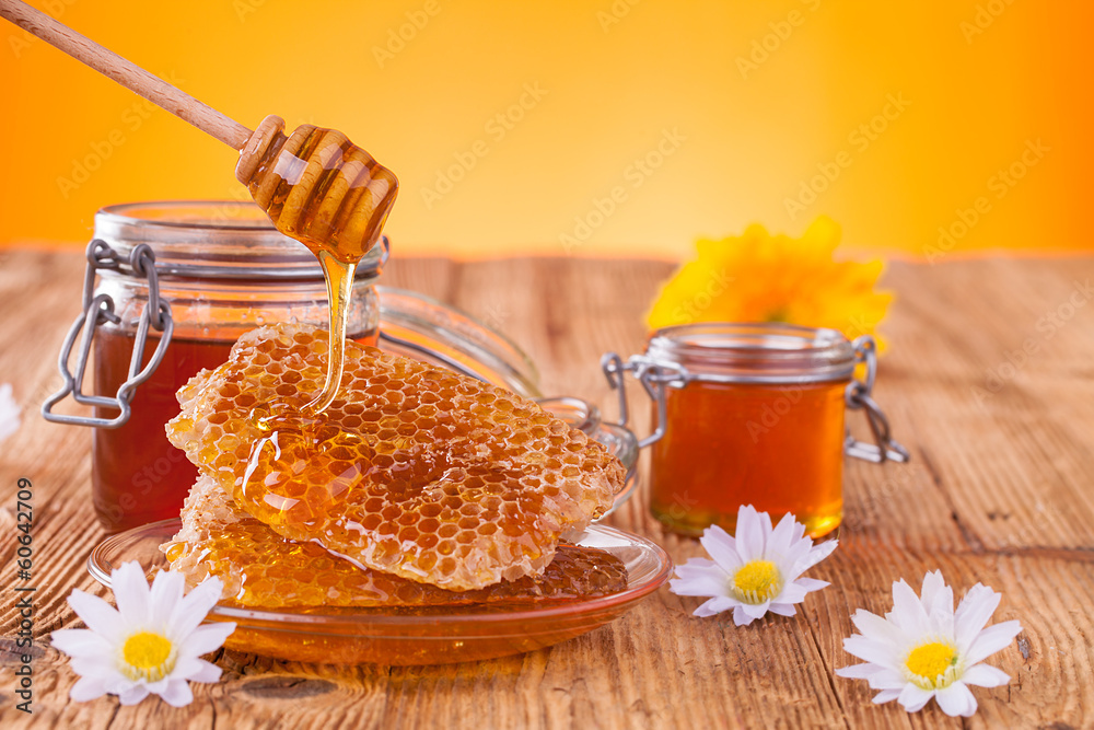 蜂蜜装在带有蜂窝和木制淋嘴的罐子里