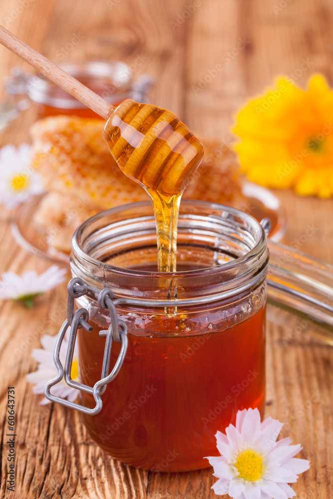 蜂蜜装在带有蜂窝和木制喷头的罐子里