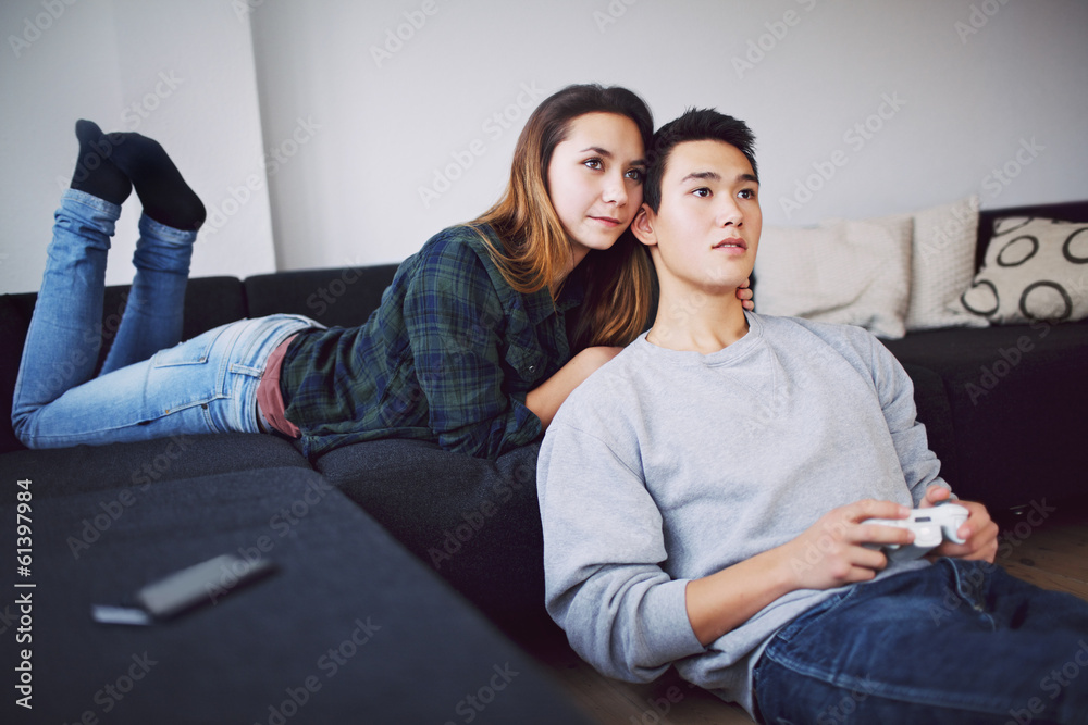 Young man playing video game with girlfriend