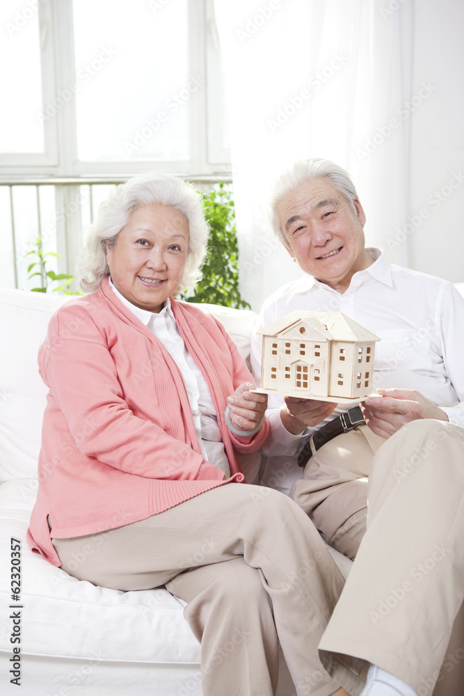 。老年夫妇抱楼模型。