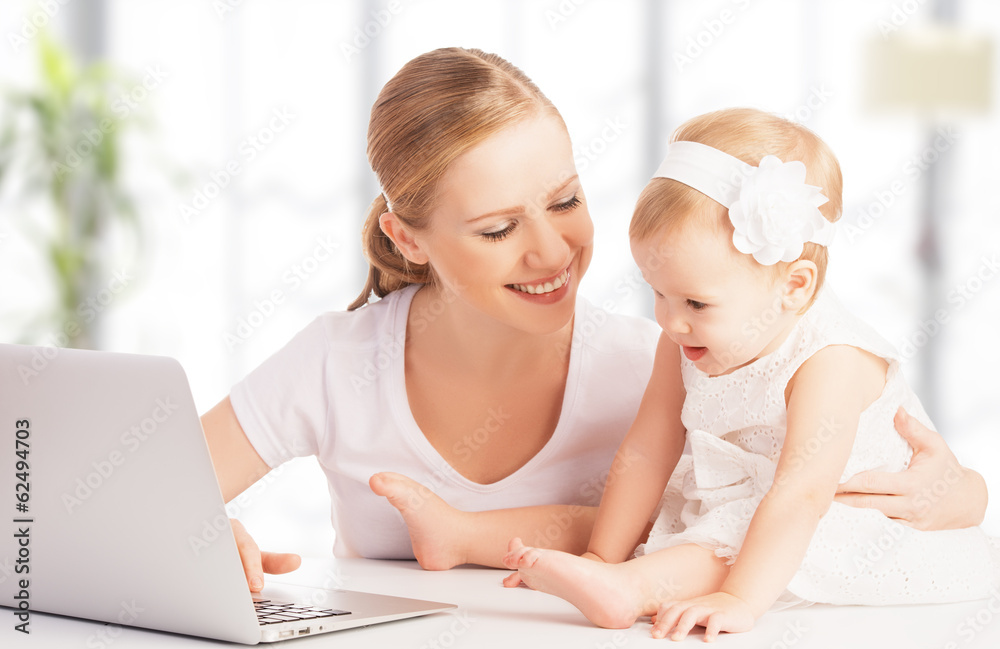 母亲和婴儿在家使用笔记本电脑