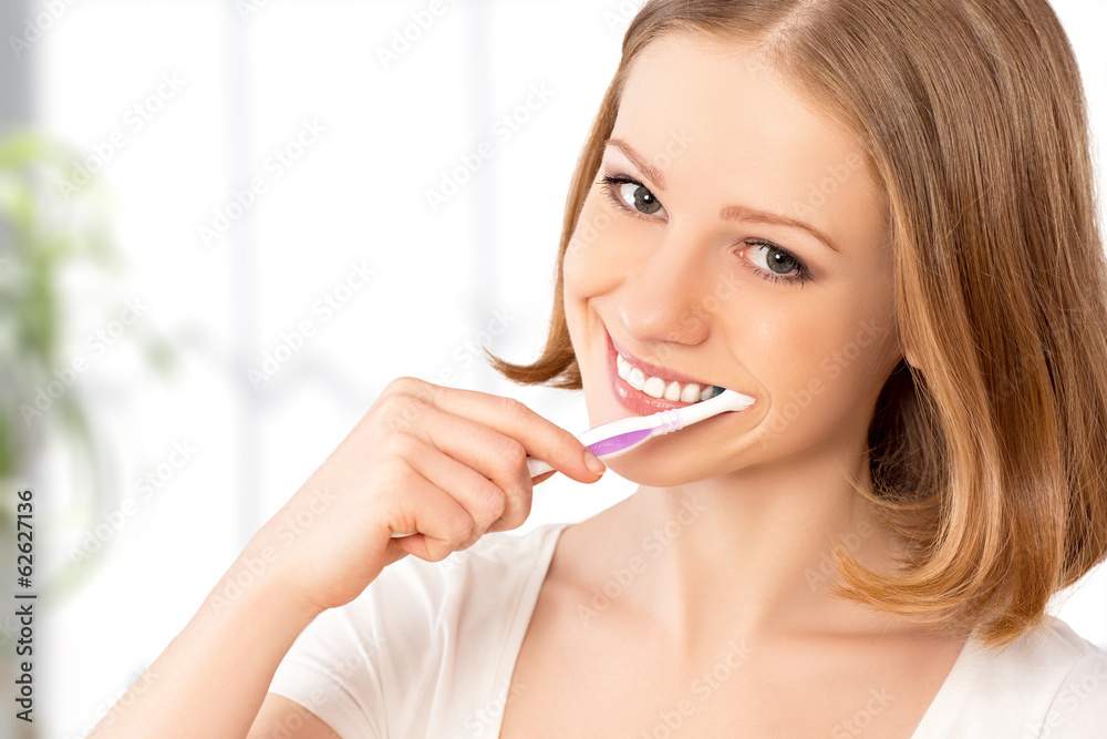 快乐的女人用牙刷刷牙