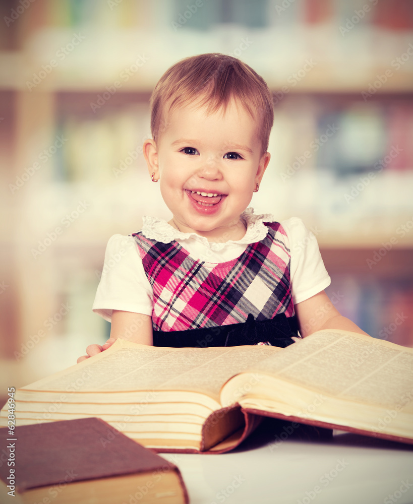 快乐的女婴在图书馆看书