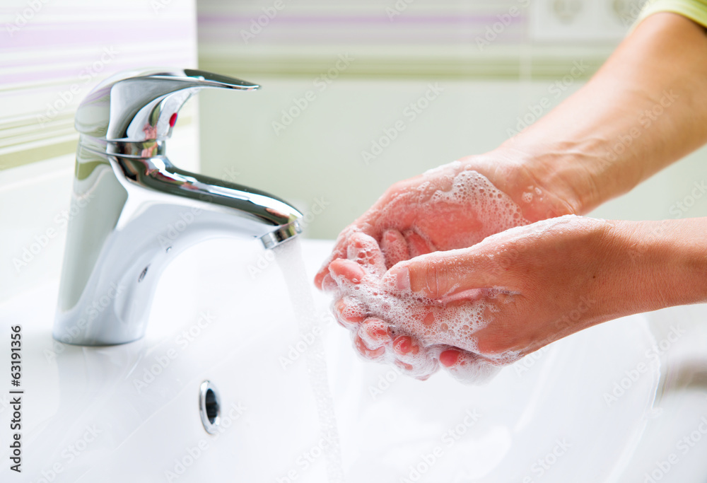 用肥皂洗手。女人在浴室洗手