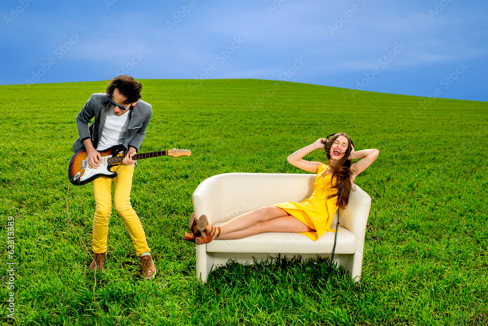 男人在吉他上独奏，女孩躺在沙发上