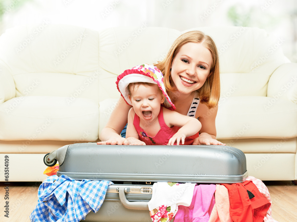 带着行李箱和衣服的母亲和女婴准备旅行