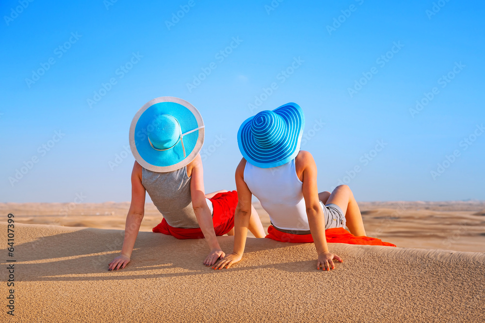 两个戴帽子的女孩在沙漠中放松