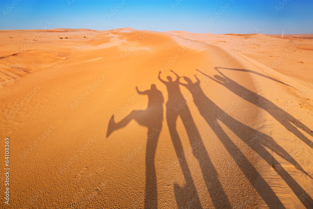 四个人在沙漠中嬉戏的影子剪影