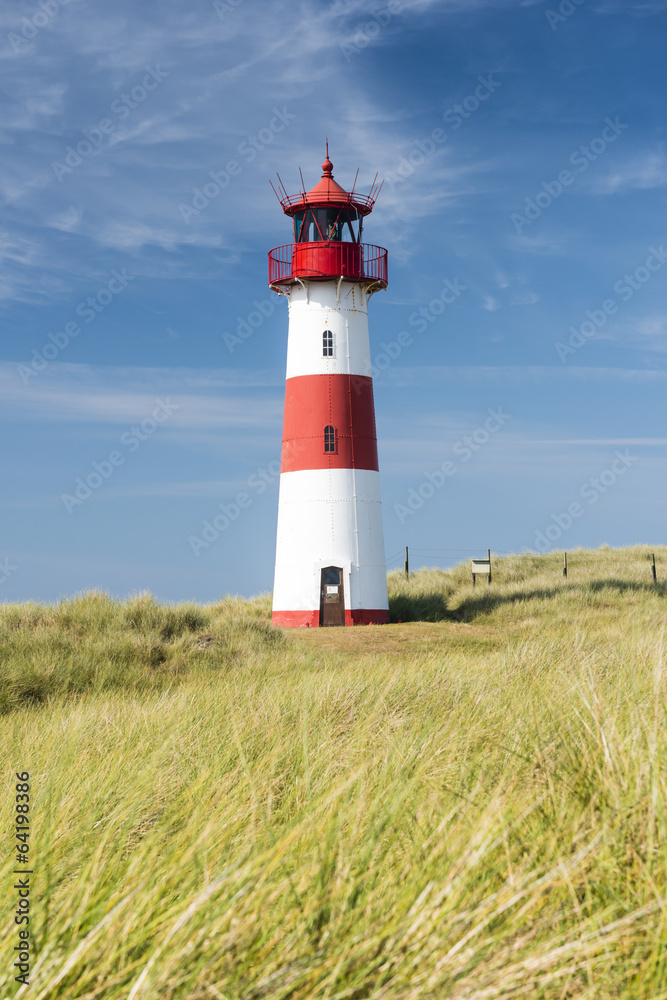 在令人惊叹的德国西尔特岛上宽阔的沙丘上的红白灯塔。