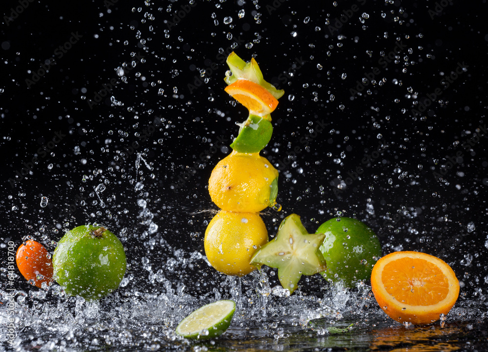 Citrus fruit in water splash on black background