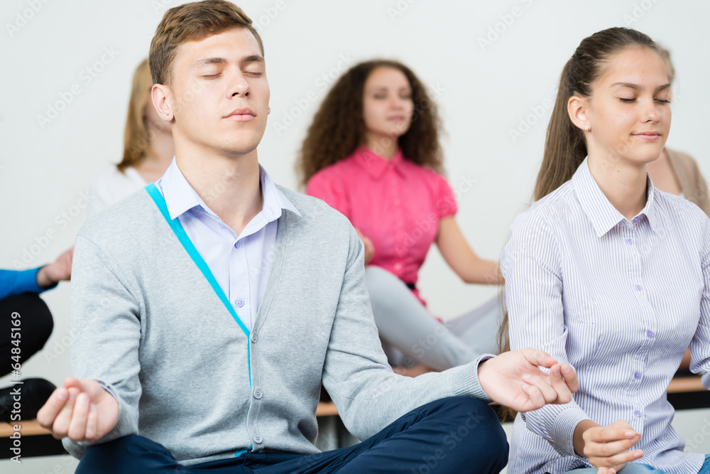 group of young people meditating